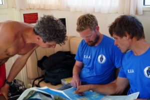 Directors George Koutsouflakis and Peter Campbell discuss the research plan while diver Anastasis Agathos looks on by V Mentogianis