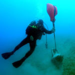 photo of diver with discovery at Butrint V site